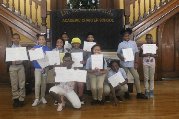 Fifth-grade students are proud to hold their honor roll certificates.
